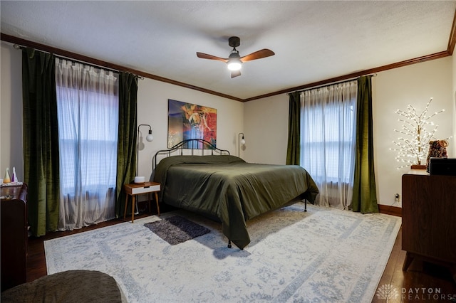 bedroom featuring crown molding, dark hardwood / wood-style floors, and ceiling fan