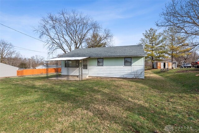 rear view of property featuring a shed and a lawn