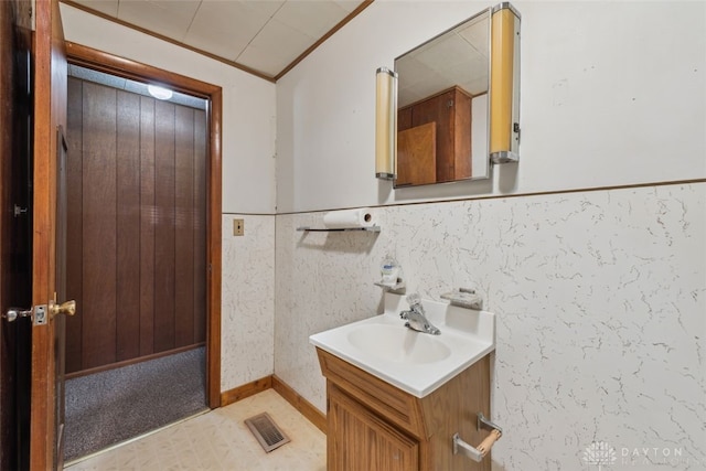 bathroom with a wainscoted wall, visible vents, ornamental molding, and vanity