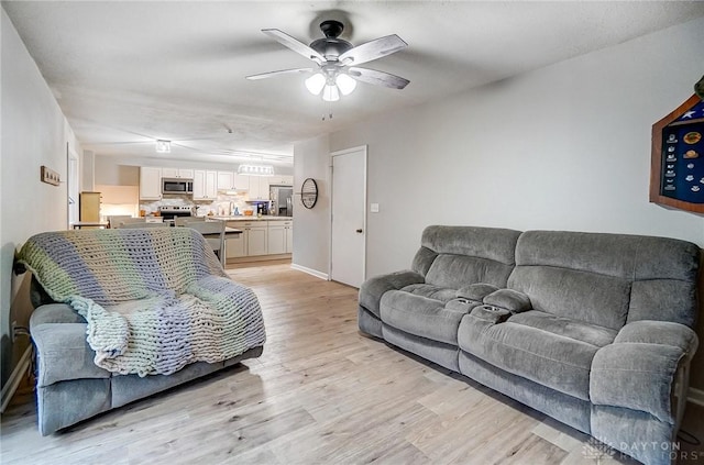 living room featuring ceiling fan and light wood-type flooring