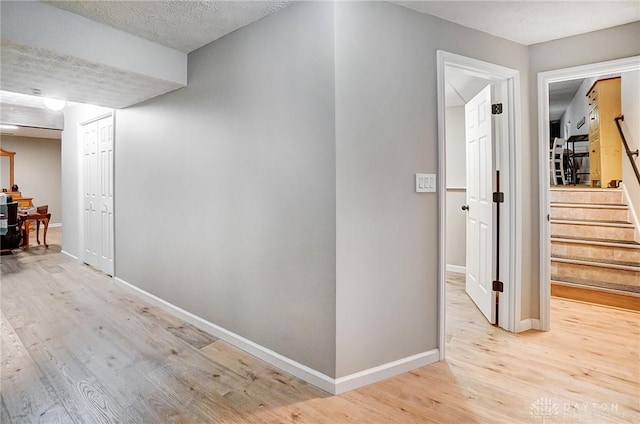 corridor featuring hardwood / wood-style flooring and a textured ceiling