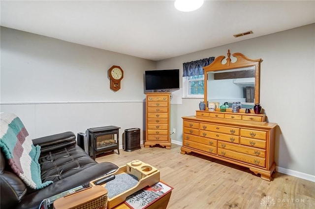 sitting room featuring hardwood / wood-style flooring and a wood stove