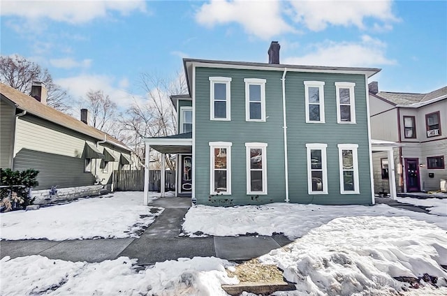 view of snow covered back of property