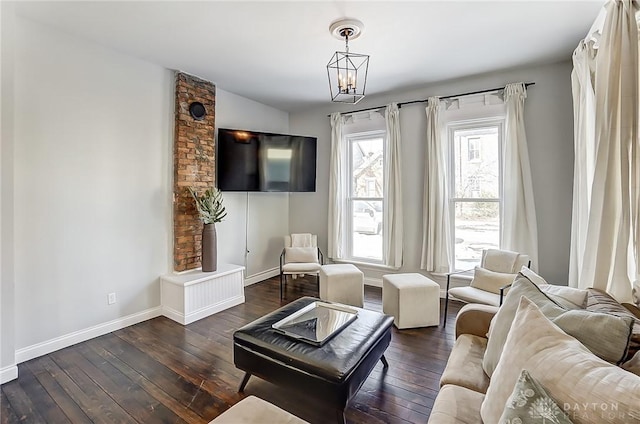 living room with dark hardwood / wood-style flooring, a notable chandelier, and vaulted ceiling