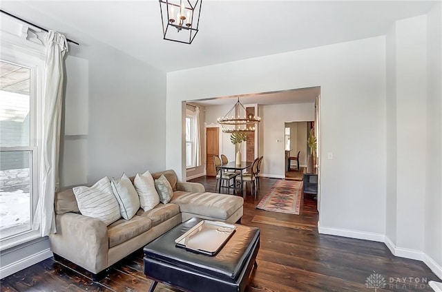 living room with an inviting chandelier, dark hardwood / wood-style flooring, and plenty of natural light