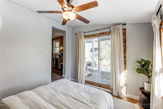 bedroom with access to exterior, light hardwood / wood-style floors, and ceiling fan