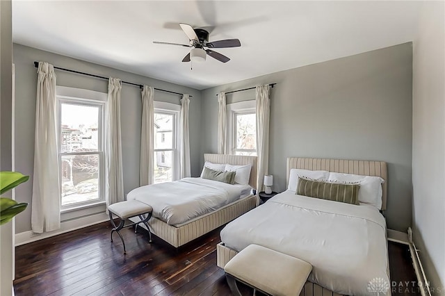 bedroom featuring multiple windows, ceiling fan, and dark hardwood / wood-style flooring