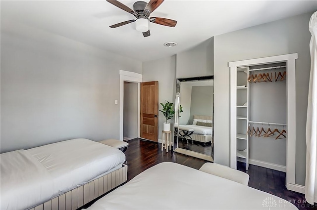 bedroom featuring dark wood-type flooring, a closet, and ceiling fan