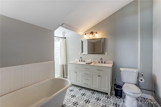 bathroom with vanity, lofted ceiling, a bathtub, and toilet