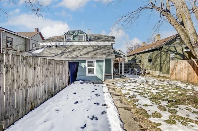 view of snow covered rear of property