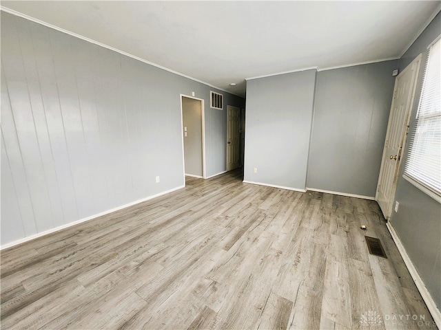 empty room featuring light hardwood / wood-style flooring and ornamental molding