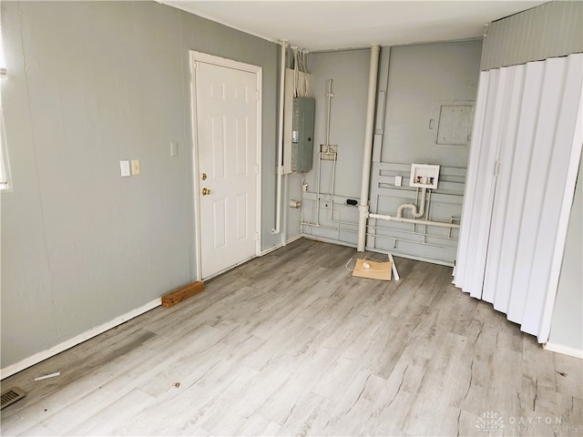 interior space with light hardwood / wood-style flooring and electric panel