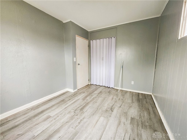 unfurnished room with crown molding and light hardwood / wood-style flooring