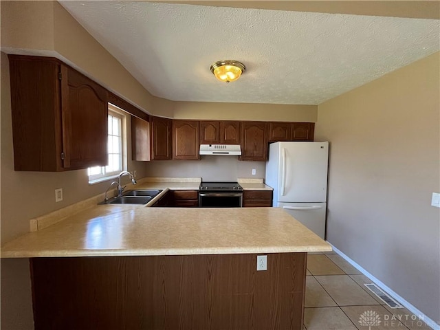 kitchen featuring sink, white fridge, light tile patterned floors, kitchen peninsula, and stainless steel electric range