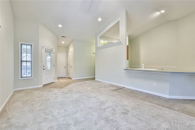 carpeted foyer entrance with vaulted ceiling