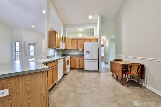 kitchen featuring high vaulted ceiling, sink, and white appliances