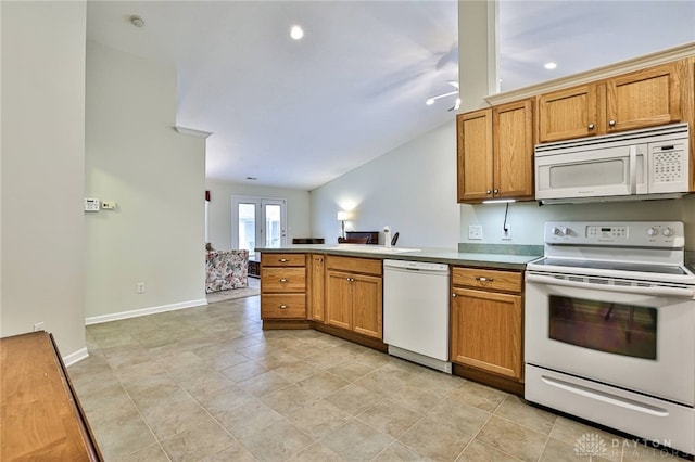 kitchen with vaulted ceiling, sink, white appliances, and kitchen peninsula