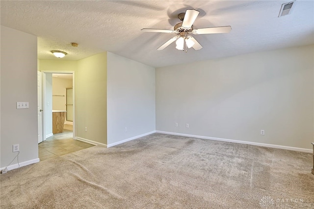 carpeted empty room featuring ceiling fan and a textured ceiling