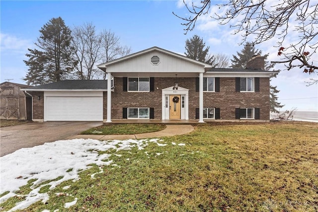 raised ranch with cooling unit, a garage, and a front lawn