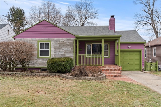 view of front of home featuring a porch, a garage, and a front yard