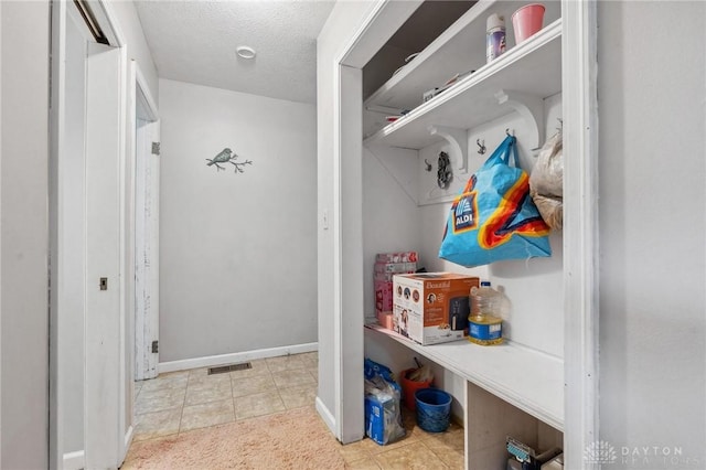 mudroom featuring light tile patterned floors and a textured ceiling