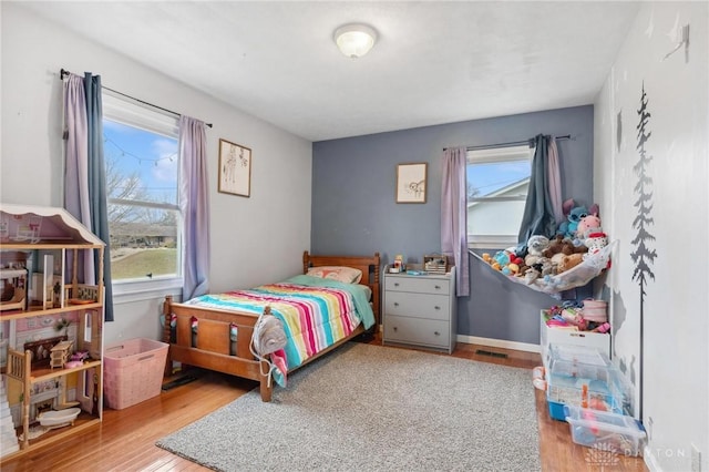 bedroom featuring multiple windows and light hardwood / wood-style floors