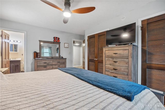 bedroom with ceiling fan, ensuite bath, and multiple closets