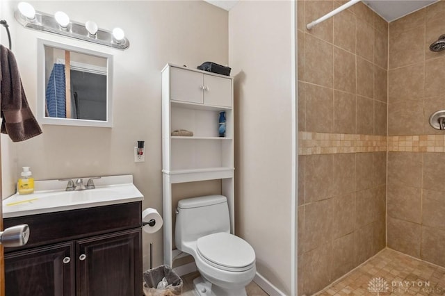 bathroom featuring vanity, toilet, and a tile shower