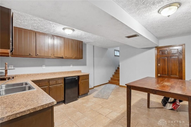 kitchen featuring refrigerator, sink, and a textured ceiling