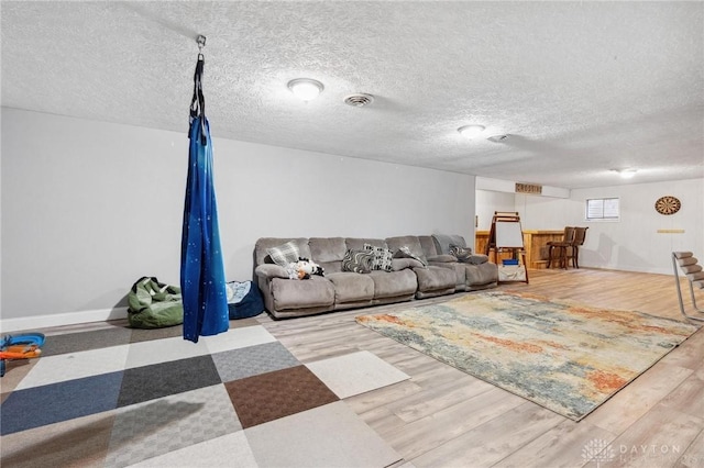 living room featuring a textured ceiling and light hardwood / wood-style flooring