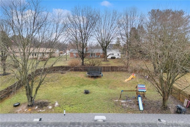 view of yard with a playground and a trampoline