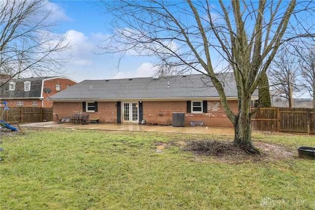 rear view of property featuring a patio, central AC unit, and a lawn