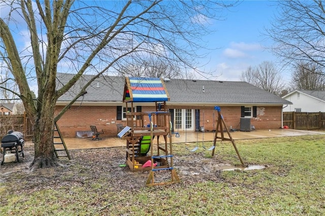 rear view of property with a playground, a patio area, and a lawn