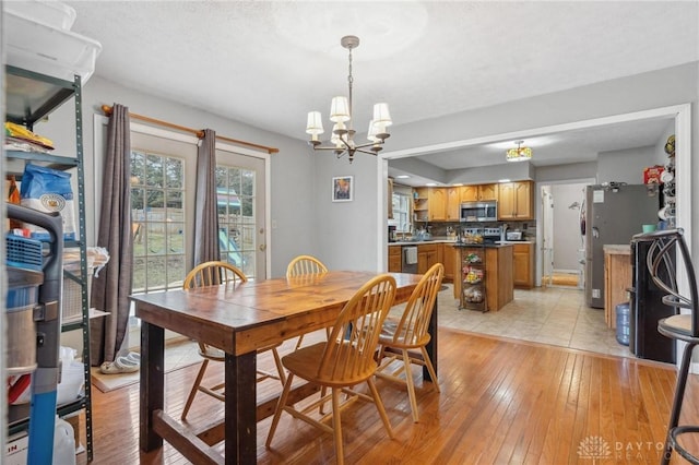 dining area featuring an inviting chandelier and light wood-type flooring