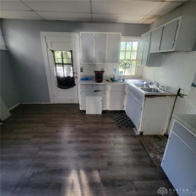 kitchen featuring white cabinetry, a paneled ceiling, dark hardwood / wood-style flooring, and sink