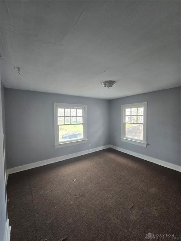 unfurnished room featuring baseboards