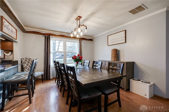 dining space featuring hardwood / wood-style flooring and ornamental molding