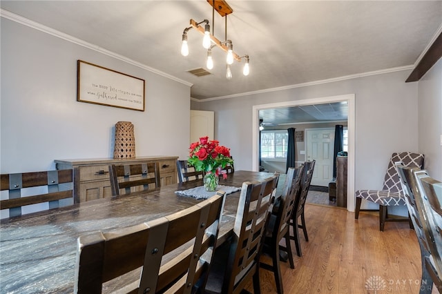 dining room featuring crown molding and light hardwood / wood-style floors