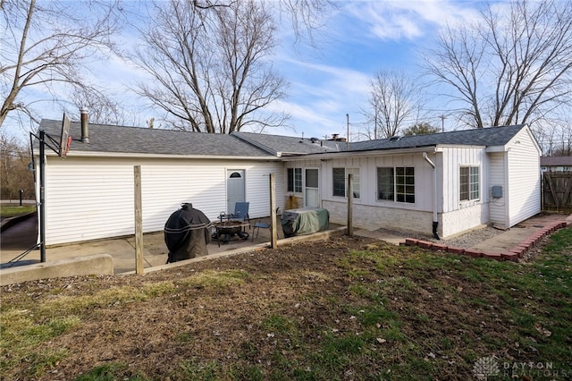 back of house with an outdoor fire pit and a patio area