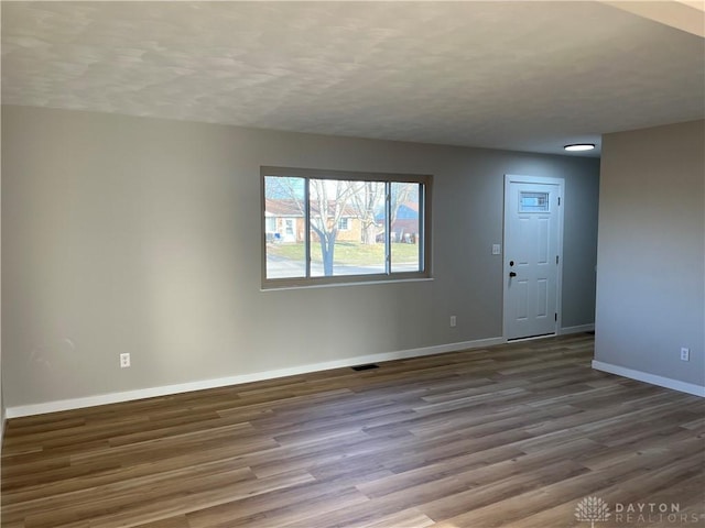 unfurnished room featuring hardwood / wood-style flooring and a textured ceiling