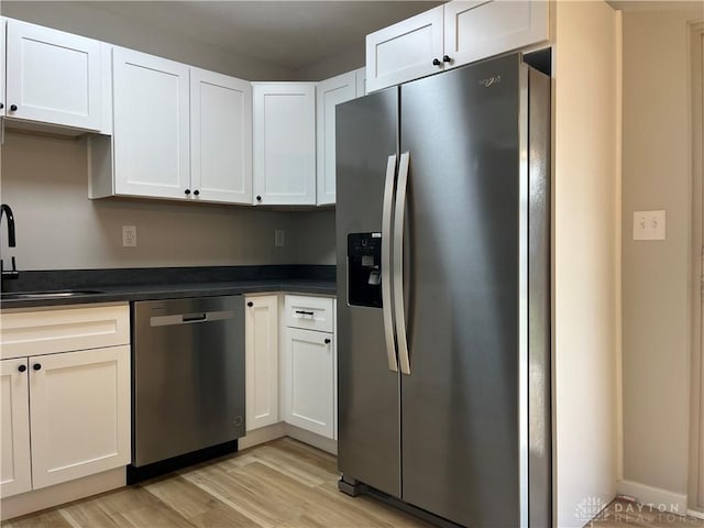 kitchen featuring white cabinetry, stainless steel appliances, light hardwood / wood-style floors, and sink