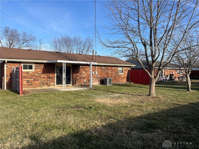 rear view of property with a yard, central AC unit, and a patio area