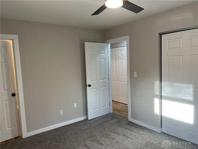 unfurnished bedroom with dark carpet and ceiling fan