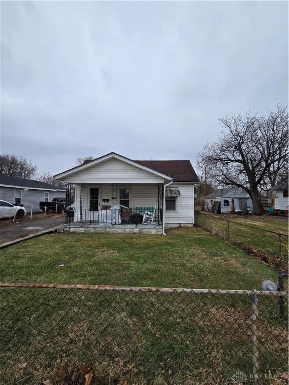 view of front of home featuring covered porch and a front lawn