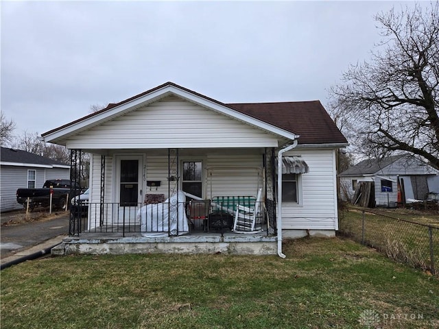 bungalow-style house with a front yard and covered porch