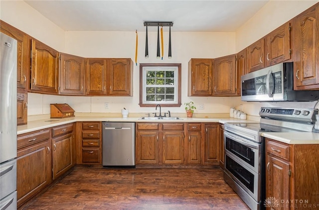 kitchen featuring stainless steel appliances, sink, pendant lighting, and dark hardwood / wood-style flooring