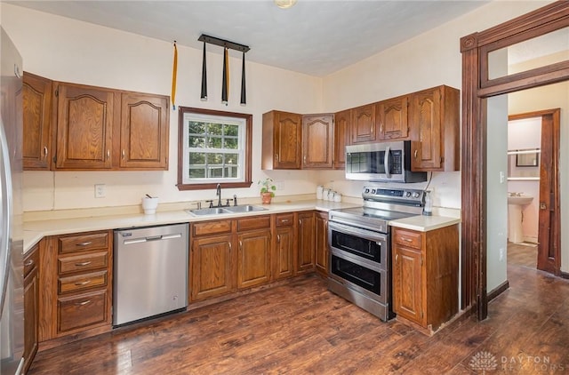 kitchen with stainless steel appliances, dark hardwood / wood-style flooring, and sink