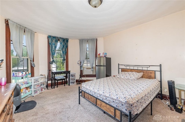 carpeted bedroom with stainless steel refrigerator