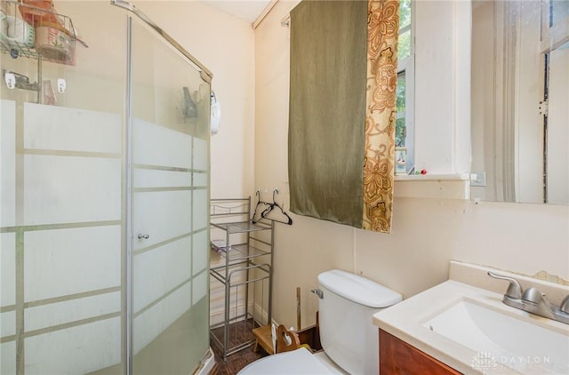 bathroom featuring vanity, toilet, and an enclosed shower