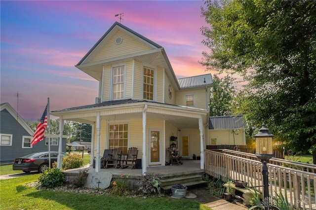 back house at dusk with covered porch